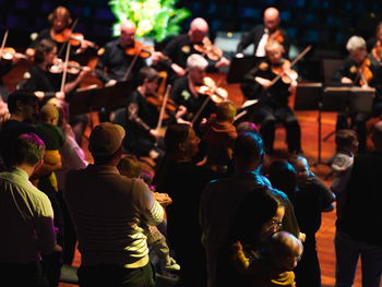 Barn og foreldre står og danser til orkestermusikk